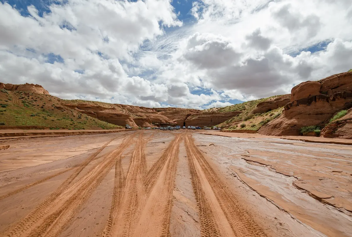 Sandige Piste durch den Wash in Richtung Antelope Canyon unter bewölktem Himmel
