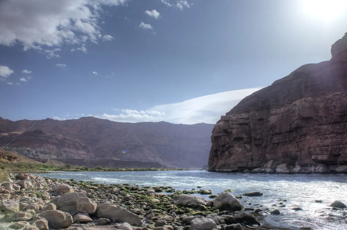 Colorado River mit steinigem Ufer und Canyonwand in der Nähe von Lees Ferry
