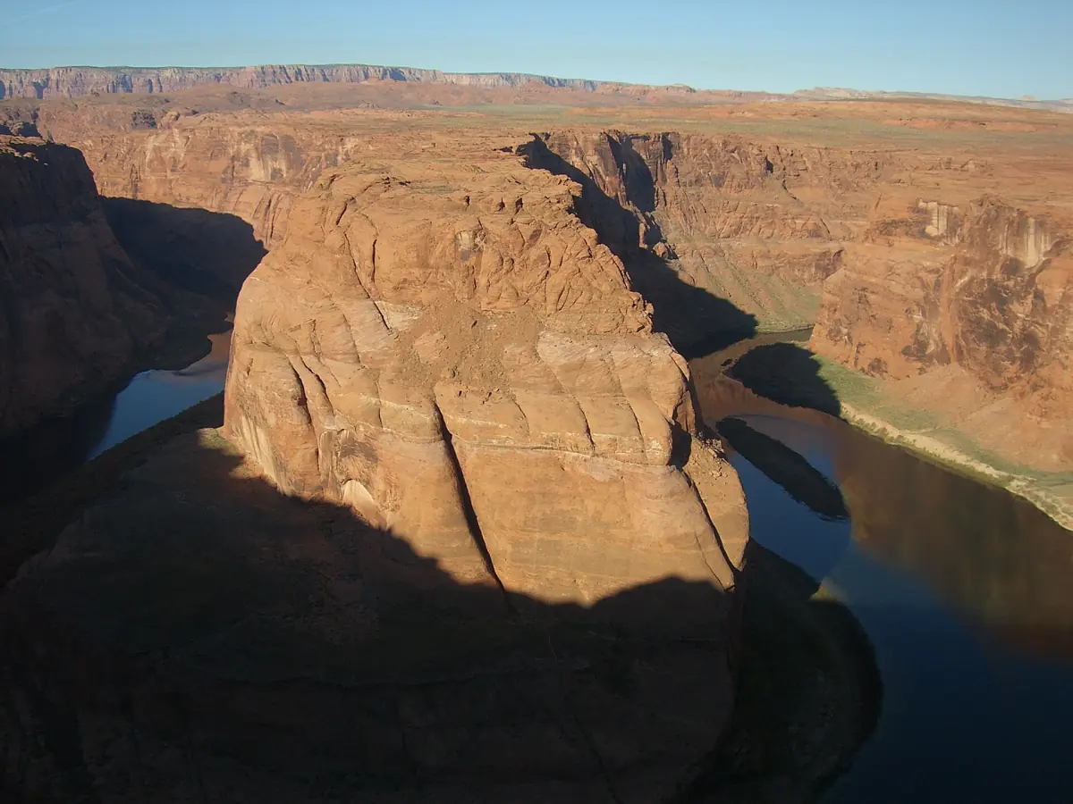 Tiefe Schatten liegen über der Flussschleife und den Sandsteinwänden am Horseshoe Bend