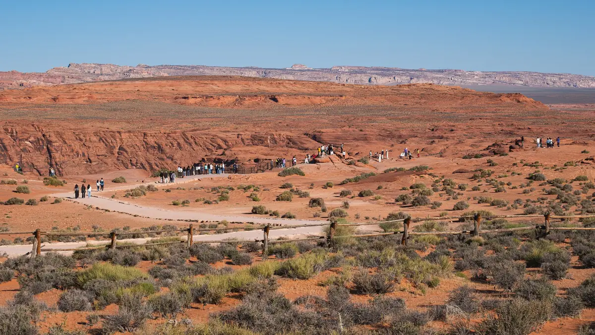 Wüstenebene mit dem Weg und Besuchern auf dem Weg zum Rand des Horseshoe Bend