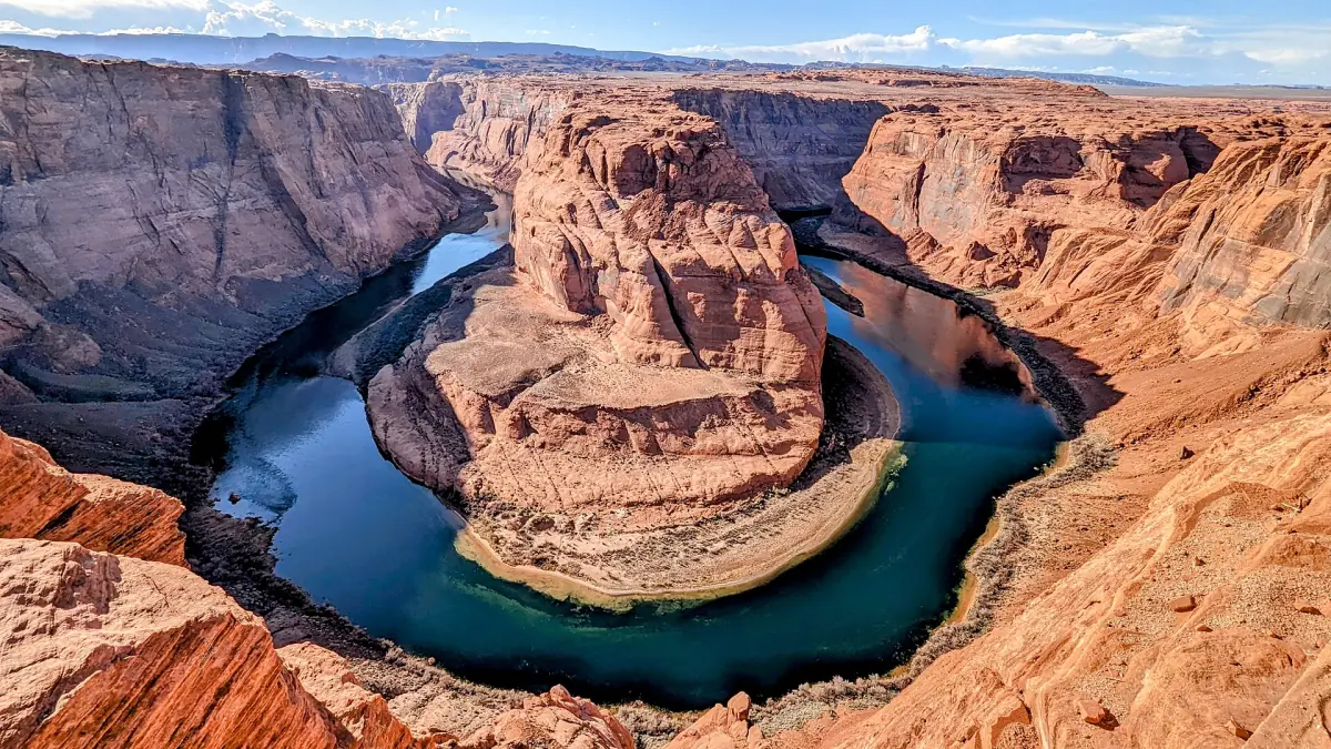 Türkisfarbener Fluss schlingt sich im warmen Nachmittagslicht um den Felsturm des Horseshoe Bend
