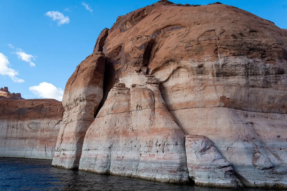 Gerundete Sandsteinwand mit heller Wasserlinie ragt aus dem Lake Powell