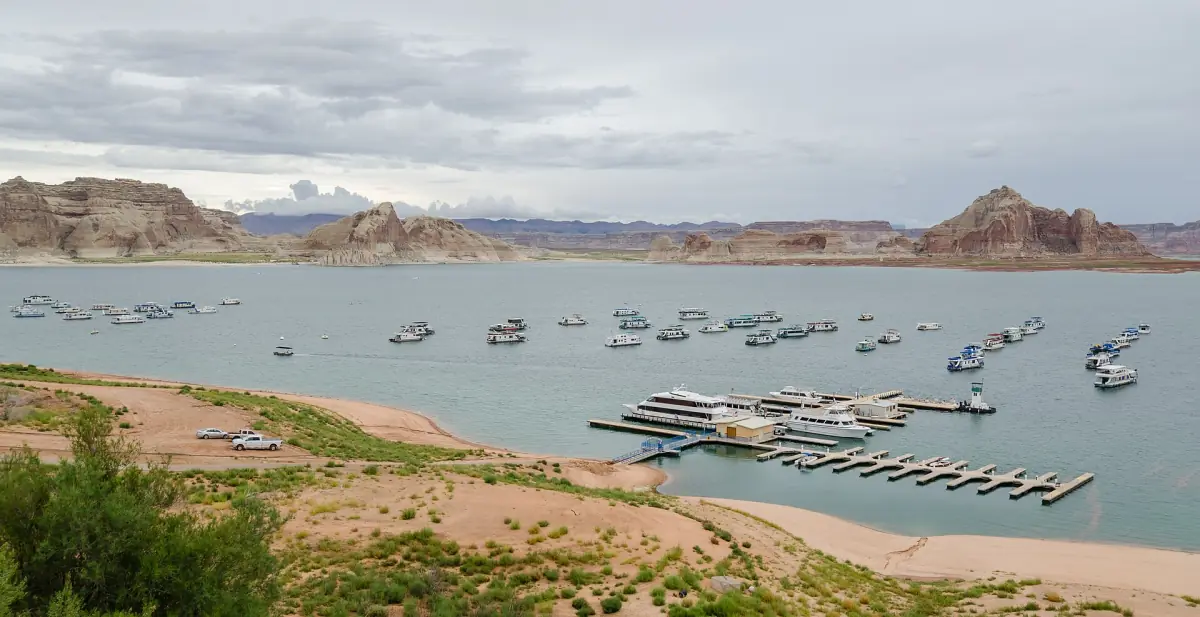 Marina am Lake Powell mit vielen festgemachten Booten unter fernen Tafelbergen