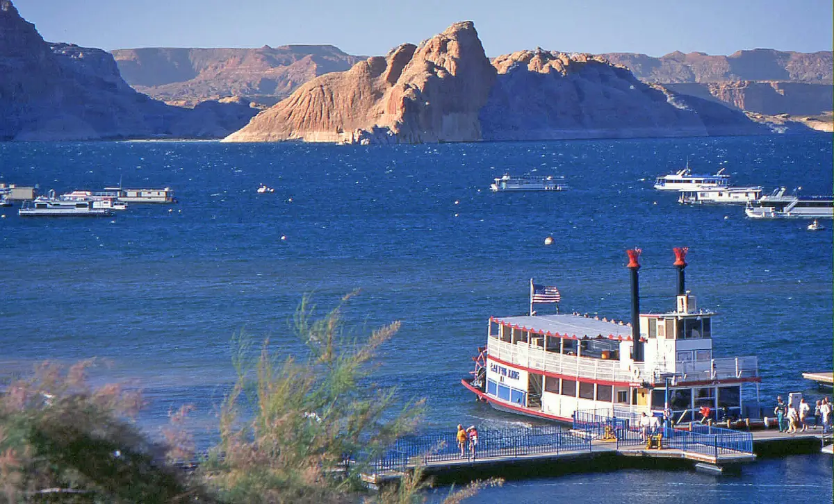 Raddampfer-Ausflugsboot am Steg mit Booten und roten Felsen auf dem Lake Powell