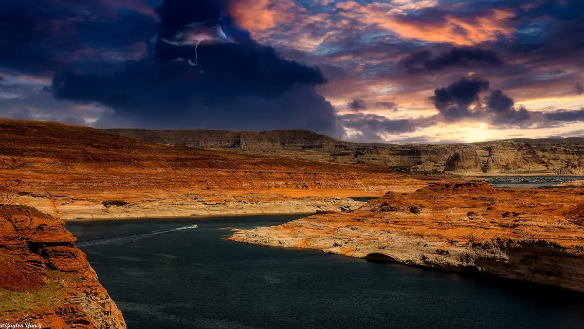 Dramatische Abendwolken über roten Felsen und dunklem Wasser am Lake Powell bei Page