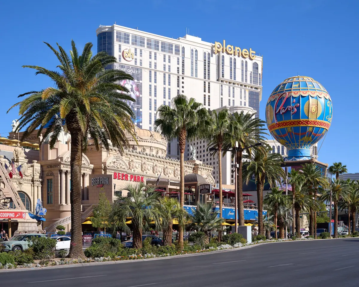 Las Vegas Strip bei Tag mit Palmen, Hotels und einem ballonförmigen Turm