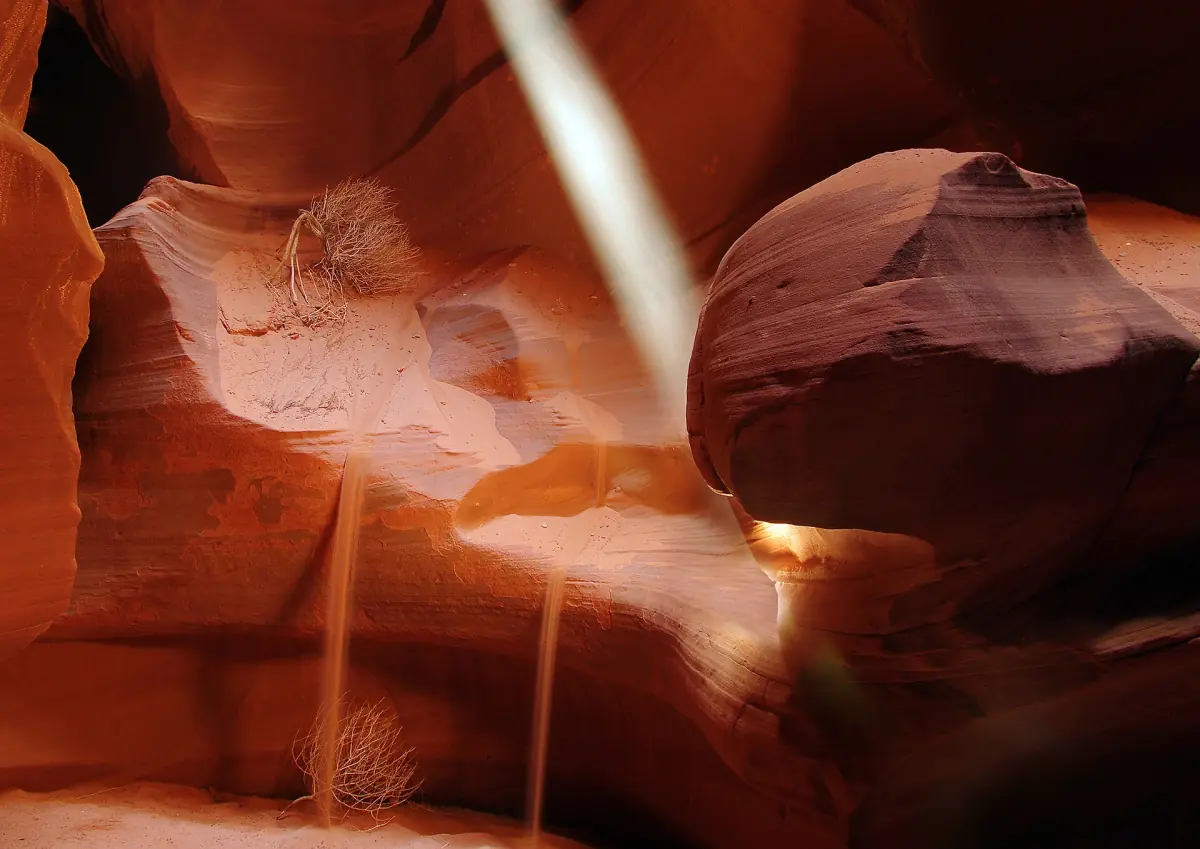 Sonnenstrahl und herabrieselnder Sand in einer engen Schlucht des Upper Antelope Canyon